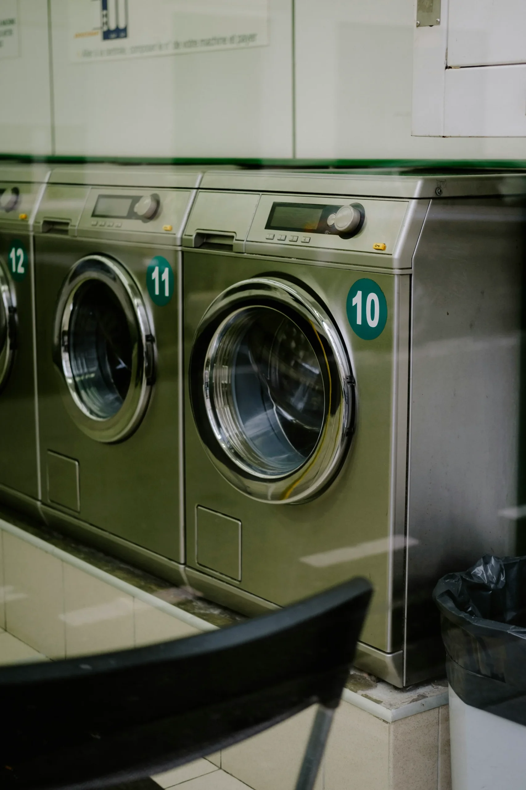 Front load washing machines lined up in a laundry room