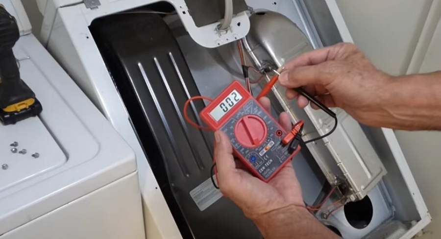 A technician testing a dryer heating element with a multimeter